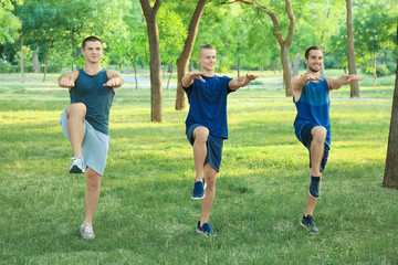 Young sporty men doing exercise outdoors