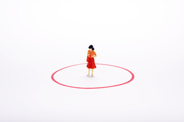miniature pople woman in red circle over white backdrop or background.