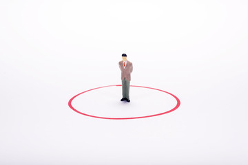 Miniature people, business man in red circle over white backdrop or background.