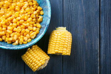 Corn kernels and cut cob on wooden background