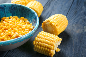 Corn kernels and cut cob on wooden background