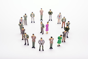 Fototapeta na wymiar Miniature business people standing in circle over backdrop or background.