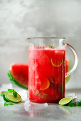 Detox water with watermelon, lime, mint and ice on light background, copy space