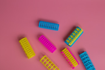 Colorful  hair curlers  on pink background. 
