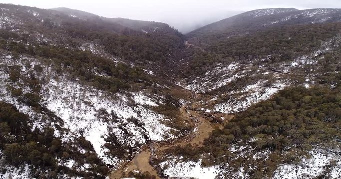 Winter snow covered mountains along creek and Guthega road from Perisher valley in Snowy mountains
