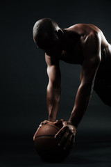 Portrait of afro american basketball player doing pushup exercise on the ball