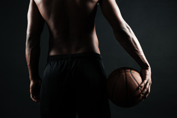 Cropped back view of afro american basketball player, holding ball