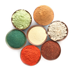 Different colorful superfood powders in bowls on white background