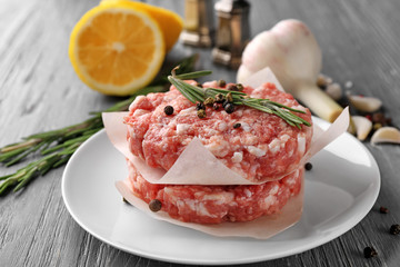 Plate with fresh minced meat on wooden table