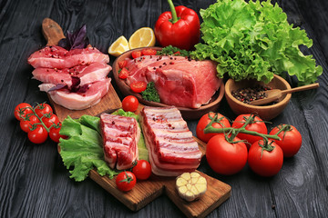 Different types of raw meat on wooden table