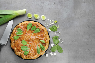 Tasty pie with spinach on grey background