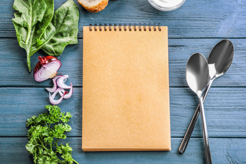 Composition with notebook and herbs on wooden background