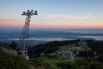 Beautiful view of the cityscape from the top of Grouse Mountain during a vibrant summer sunset. Taken in North Vancouver, British Columbia, Canada.
