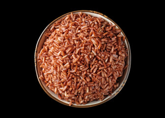 Bowl with brown rice on black background