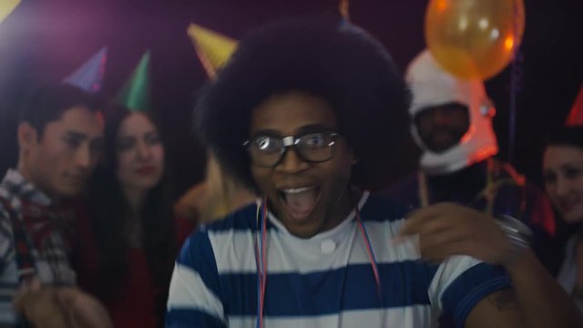  Nerdy guy standing out from the crowd with geeky dancing at house party