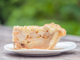 Piece of pie or puff on ceramic dish and wooden table.