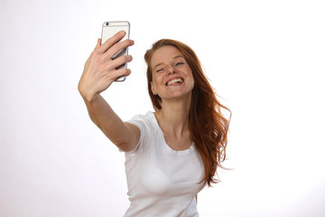 Hübsche rothaarige Frau macht ein Selfie und zwinkert