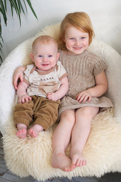 Two beautiful redheaded child on a chair