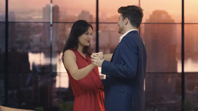  Young romantic couple dancing by the window in New York City apartment