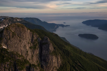 Aerial view of the North Shore Mountain, Mount Harvey, with Howe Sound in the background. Taken North of Vancouver, British Columbia, Canada, during a vibrant summer sunset.
