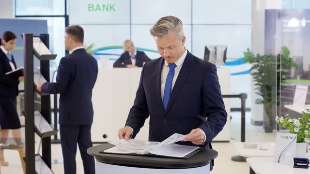  Portrait of friendly smiling financial adviser at customer help desk in bank