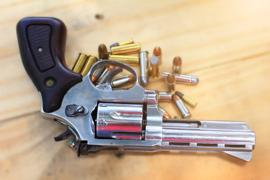 pistol with bullet on table wooden for outdoor sport and hunting