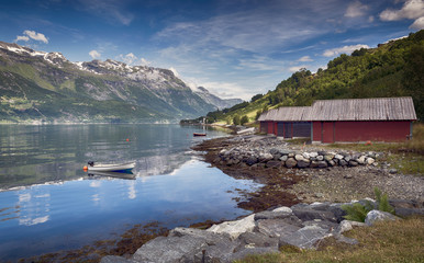 red houses and a boat in the fjord in norway