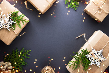 Christmas handmade gift boxes craft paper decorated on dark background top view. Merry christmas greeting card, frame. Winter xmas holiday theme. Happy New Year. Flat lay. Twinkle glitter bokeh light
