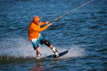 Wakeboarder, in orange shirt and helmet
