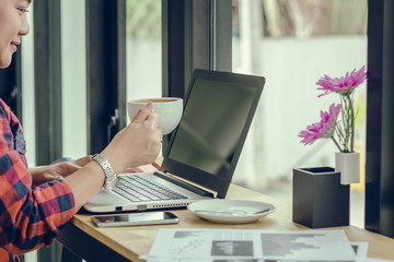 Fototapeta premium Close Up businessmen working at a coffee shop with a document with a smartphone and a laptop computer Vintage effect.