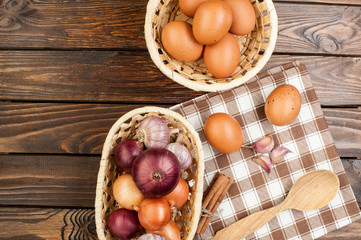 chicken eggs in basket decorated with food ingredients on wooden table