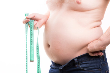 Overweight man with fat folds holding green centimeter tape in his hand closeup isolated on white...