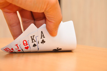 The man's hand straight in his hand. Man winning in poker