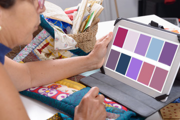 beautiful mature seamstress using tablet computer
