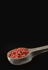 Annatto seeds in the wooden spoon - Bixa orellana