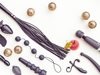 Various sex toys and Christmas decorations on a light background. Image for the festive season, for sales and discounts in sex shops. There is a free space for text