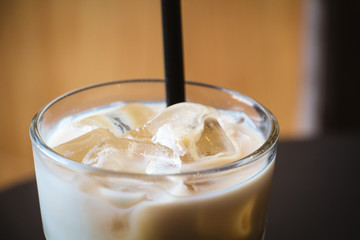 Glass of iced coffee or latte on a wooden table