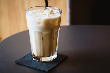 Glass of iced coffee or latte on a wooden table