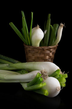 spring onions on black background