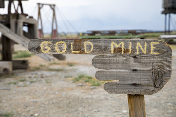 A wooden hand sign with pointing finger reading gold mine 