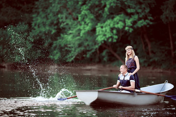 young couple rowing and splashing on lake