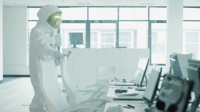  Astronaut sitting at desk in room full of computers using touch screen