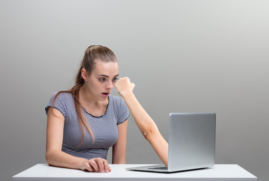 woman scared by an arm reaching out from laptop