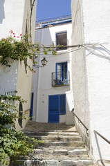 Fototapeta na wymiar Stone stairs in white alley in Cadaques, Spain