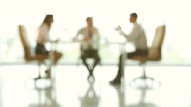 The three business partners discuss at the table. no focus