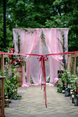 Beautiful wedding ceremony outdoors. Decorated chairs and wedding aisle with an awesome bow.....
