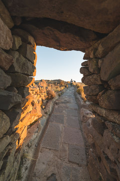 Tourist exploring Inca trails at sunset on Amantani' Island, Titicaca Lake, among the most scenic travel destination in Peru. Travel adventures and vacations in the Americas.