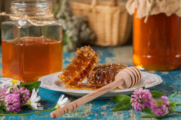 Two honey pots with honeycomb  on a wooden table  