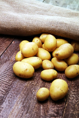 Pile of potatoes lying on wooden boards. Fresh potato