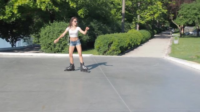 Beautiful teen girl roller-skating. Sports girl on the rollers.